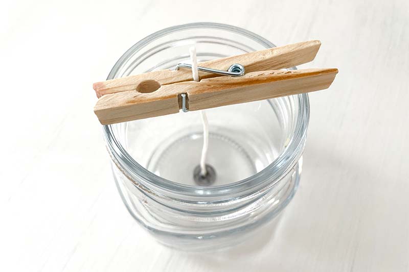 clothespin holding a candle wick in place